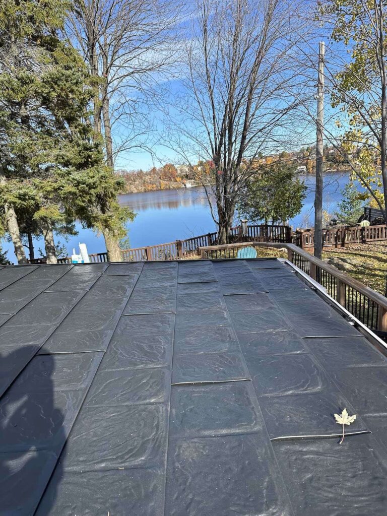 A picture of a flat roof overlooking the client's backyard. The house is overlooking a lake, with lots of trees and natural foliage surrounding it.