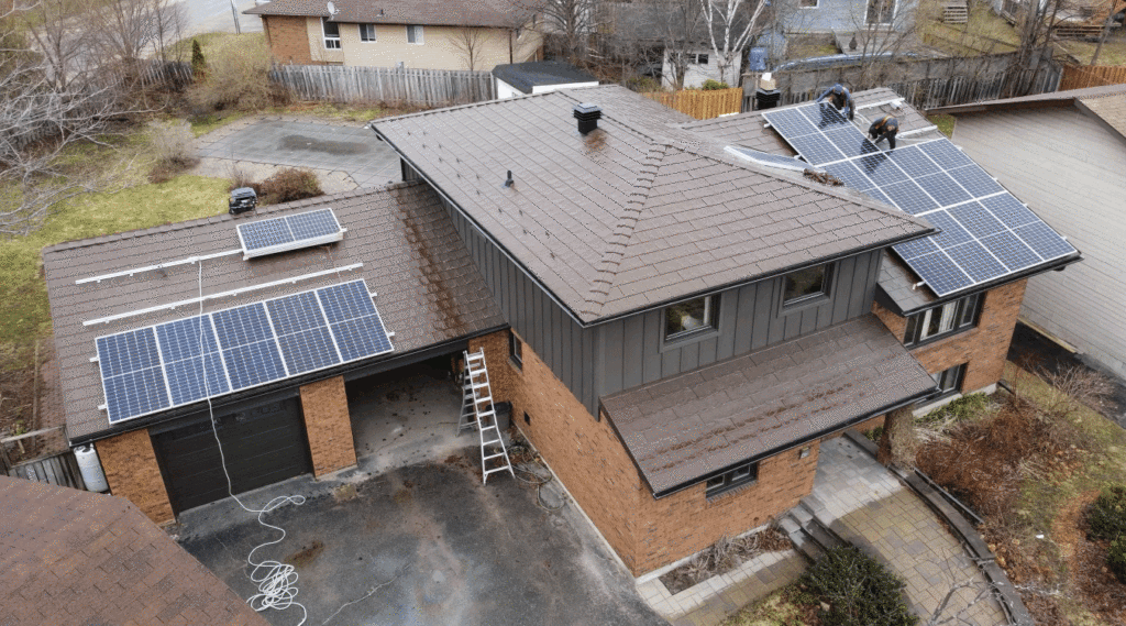 Aerial drone view of a suburban two-story brick house with a dark metal roof and newly installed solar panel system.