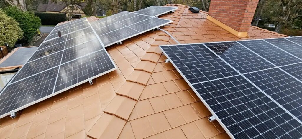 A close up image of a residential roof with many solar panels on it.