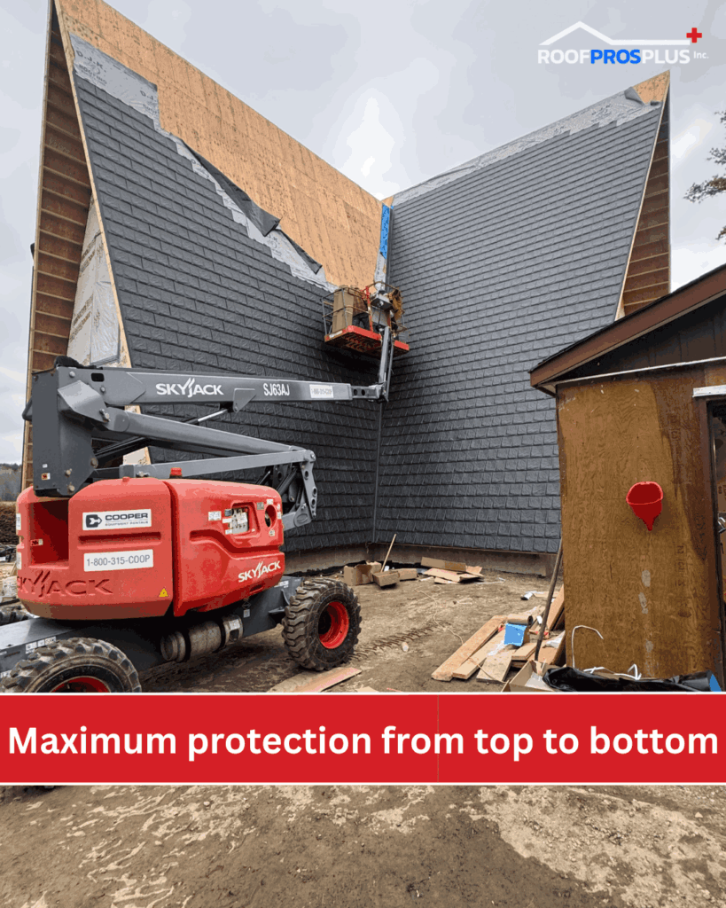 A construction worker on a lift installs metal shingles on a large, peaked roof. The lift is branded Skyjack. Text reads, "Maximum protection from top to bottom." The Roof Pros Plus logo is in the top right hand corner.