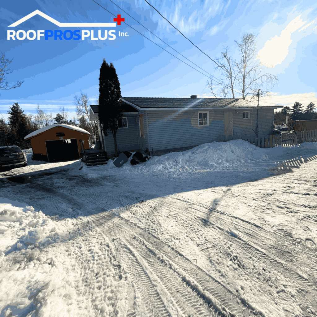 Snowy driveway leading to a single-story house with a grey exterior and a detached garage. The Roof Pros Plus Inc.” logo is visible at the top of the image.